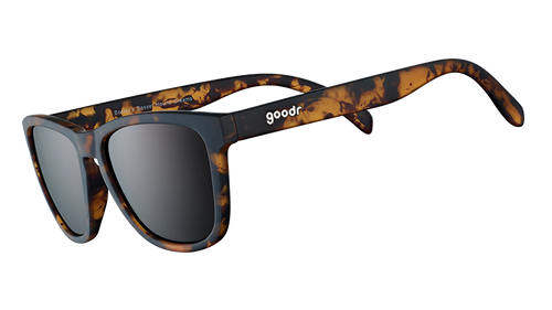 Three-quarter angle view of square brown tortoiseshell sunglasses with brown non-reflective lenses on a white background. 