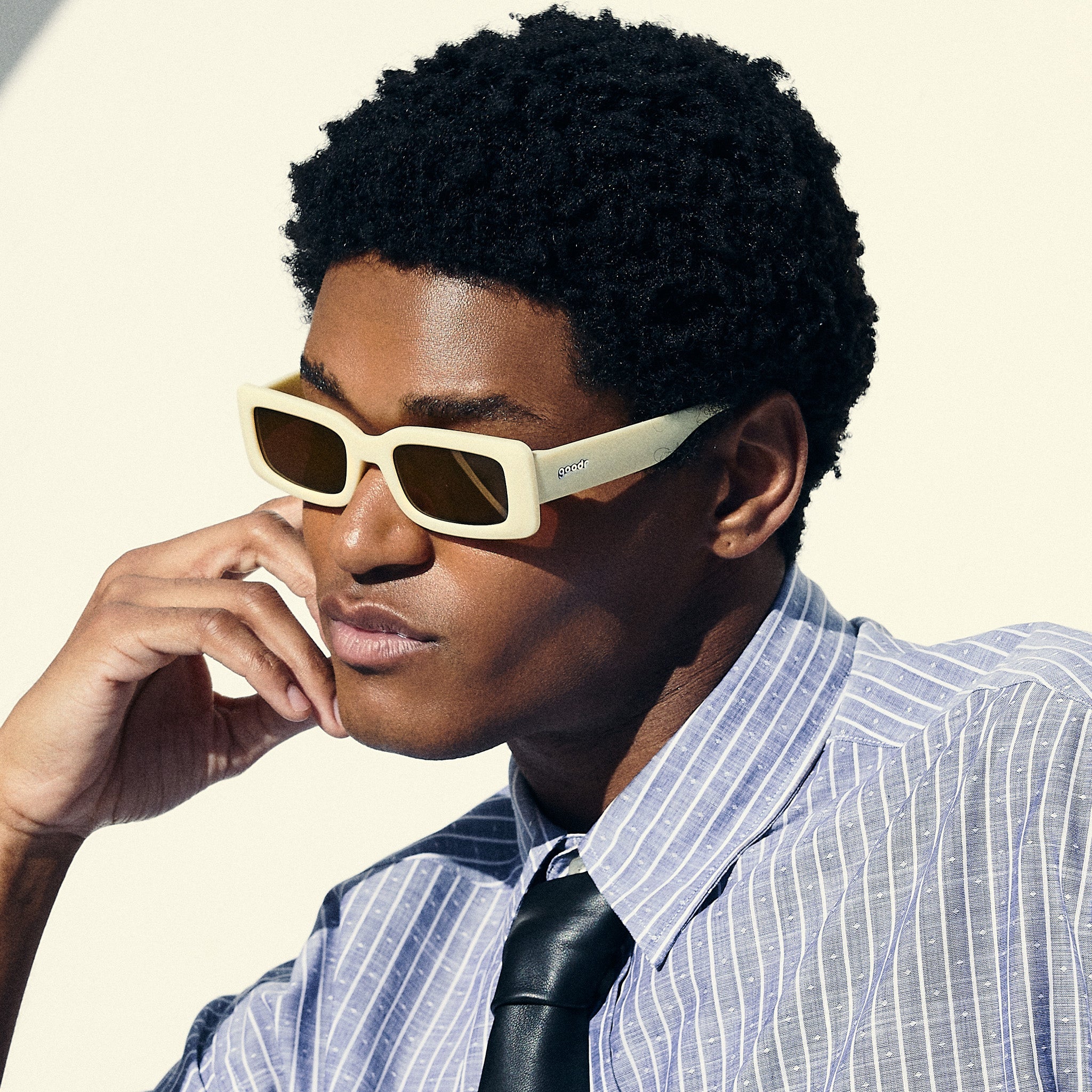 A man poses, wearing yellow rectangular sunglasses with brown-tinted polarized lenses.